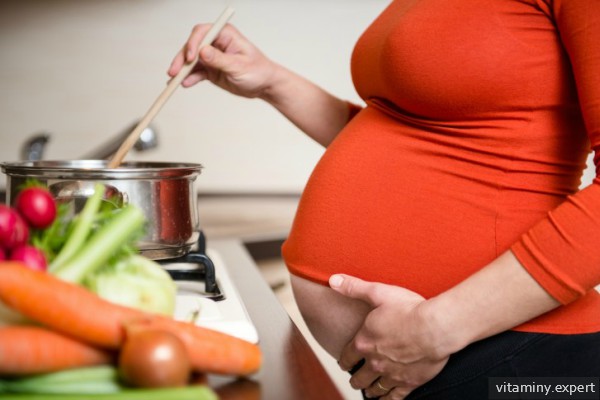 Беременная женщина у плиты