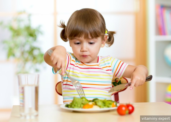 Девочка ест овощи
